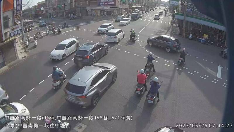 平鎮派出所警員（路中央）騎警用機車開道，護送後方（右上）轎車送孕婦到醫院。（記者李容萍翻攝）