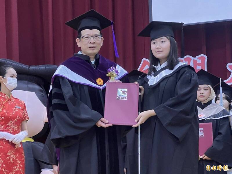 金大視障畢業生謝嘉玲（右）僅0.1視力，苦讀4年，從金大校長陳建民（左）手中領到畢業證書。（記者吳正庭攝）
