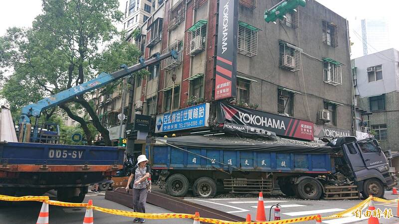 北市信義區松德路發生砂石車撞進民宅案，因車子撞擊承重柱，北市府擔心若貿然移車，恐導致整間房子有傾倒之虞，目前由工程人員在店家走廊架設承重鋼柱，再拖走肇事砂石車。（記者廖振輝攝）