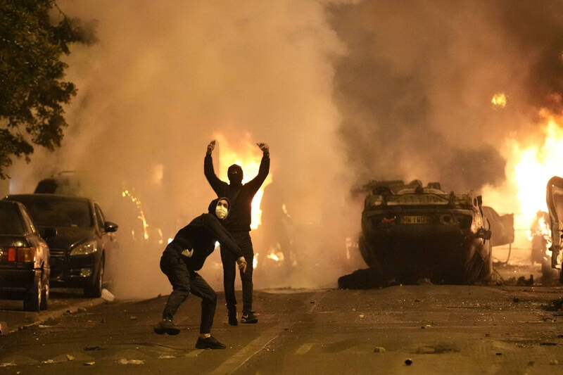 抗議演變成暴動，巴黎街頭車子被掀翻，到處縱火與警對峙。（美聯）
