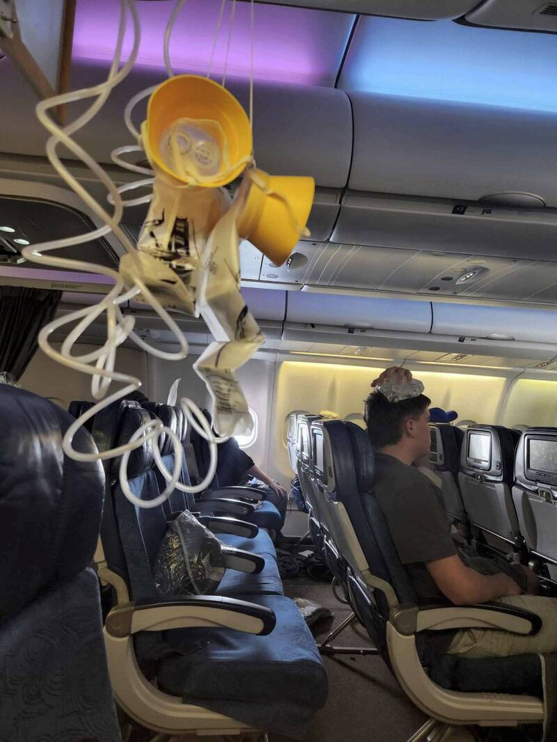 夏威夷航空上週五（6/30）一架飞往澳洲雪梨的班机遭遇严重乱流，造成机上乘客及空服员共7人受伤。图为机上乘客拍摄，乱流后氧气罩掉落，一名乘客受伤正在冰敷。（美联社）(photo:LTN)