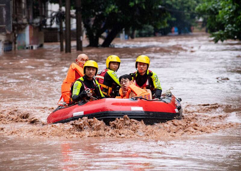 中國多個省份遭遇強降雨，據重慶應急管理局統計，重慶市已有13萬人受災、15人死亡和4人失蹤，經濟損失預估達人民幣2億2784萬元（約新台幣9.8億元）。圖為當地救難人員用橡皮艇運送居民。（路透）