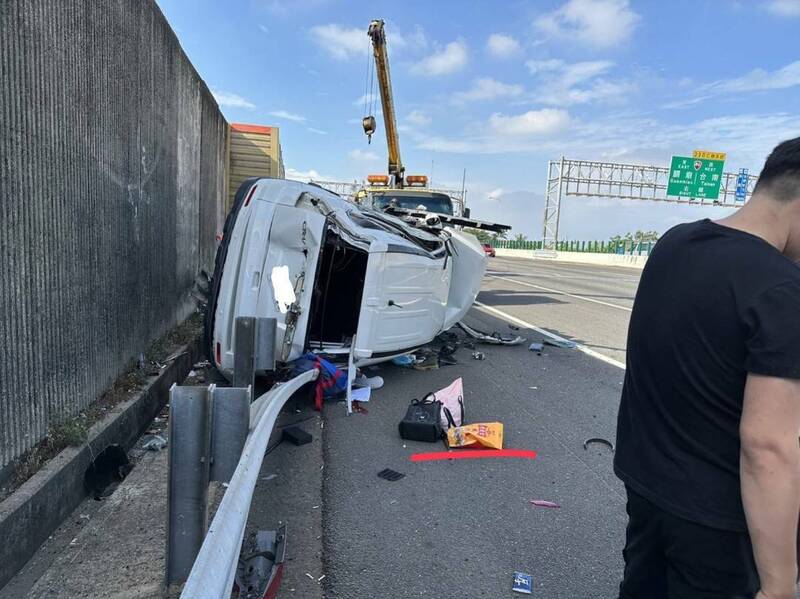 國道一號北上仁德路段，白色休旅車為閃避突然變換車道的另一輛休旅車，撞上國道護欄後側翻，車上1男1女受傷送醫。（讀者提供）