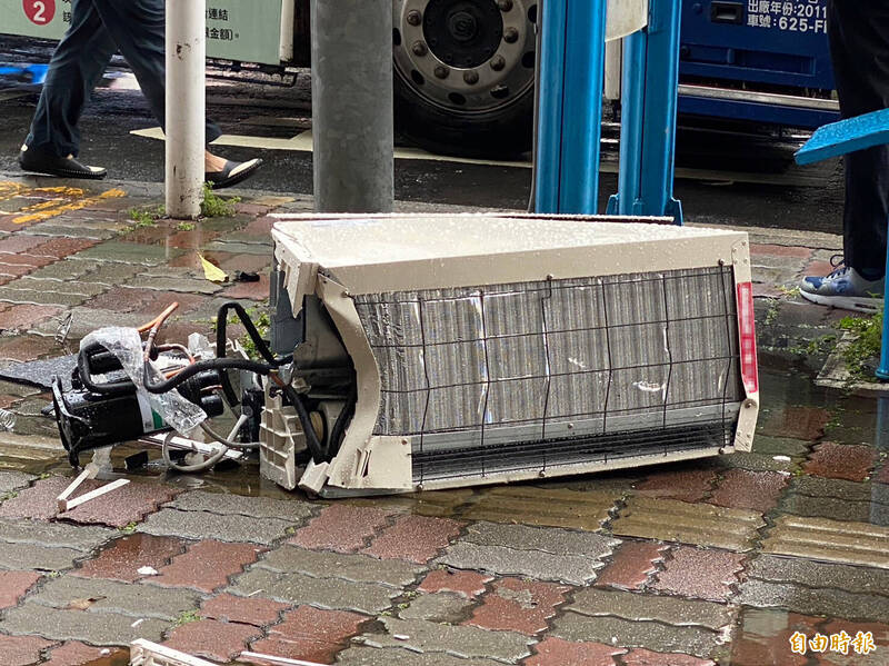 新北市板橋區捷運新埔站2號出口公車站，今天下午驚傳一名等公車的22歲黃姓女子遭當地大樓17樓掉落的冷氣砸中意外，圖為掉落的冷氣機。（記者吳仁捷攝）