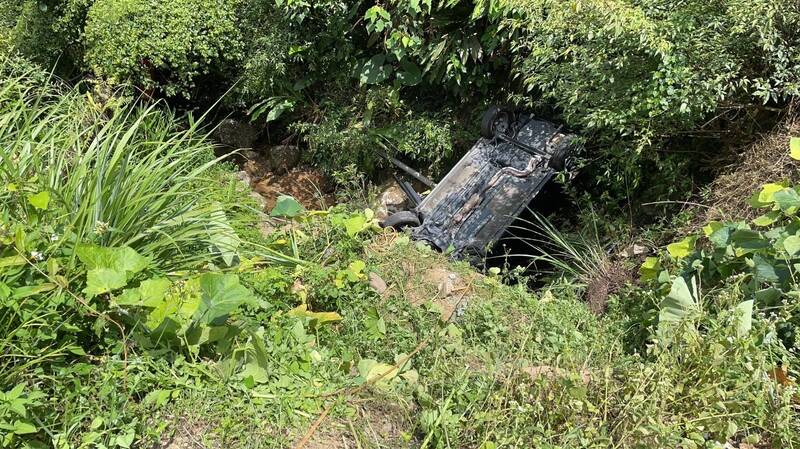 6旬婦人今天上午駕車載友人前往新北市貢寮區桃源谷道爬山前，疑倒車不慎，整輛車翻落20公尺深山谷；經新北市消防局第六救災救護大隊員將她救出時，已無呼吸心跳，送醫急救中。（記者林嘉東翻攝）