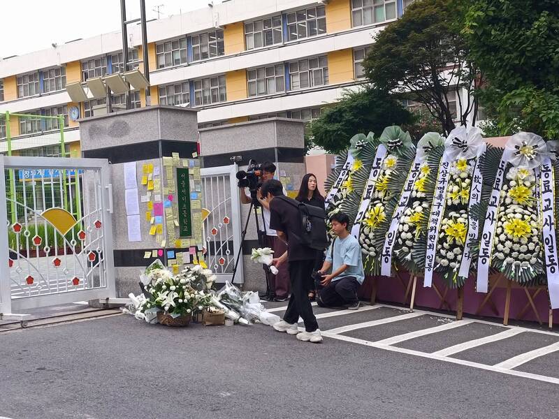 南韓首爾瑞草區一處小學的20來歲女教師，疑似因處理校園暴力案、遭學生家長辱罵，在教室內尋短身亡。圖為民眾在事發小學哀悼。（圖擷自@koryodynasty推特）