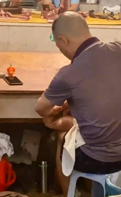 民众拍下中国四川一名肉贩老板，竟直接在摊贩前拿着切肉刀刮自己的脚皮，恶心画面令网友直唿太缺德。（撷取自微博）(photo:LTN)