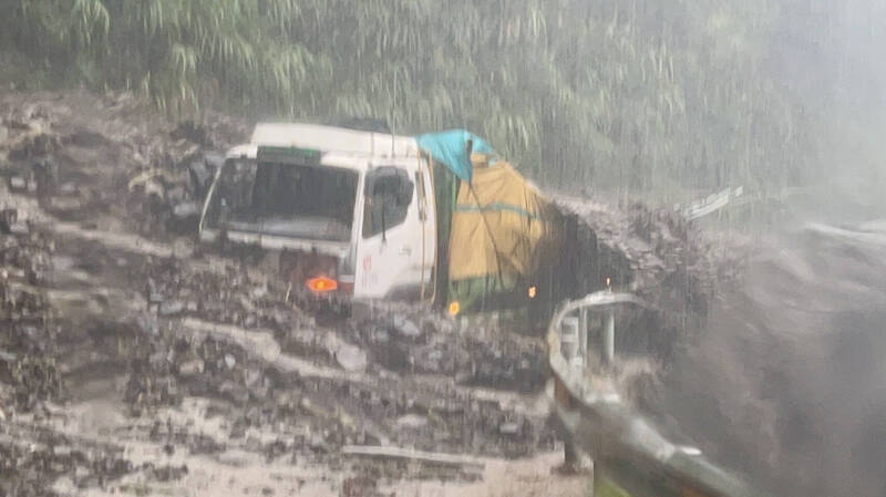 投89線4K土石泥流沖下，大貨車陷入動彈不得，幾乎快被土石淹沒。（民眾提供）