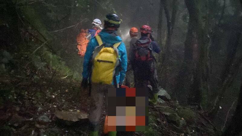 搜救人員徹夜救援，以捲式擔架搬運女登山客下山。（嘉義縣消防局提供）