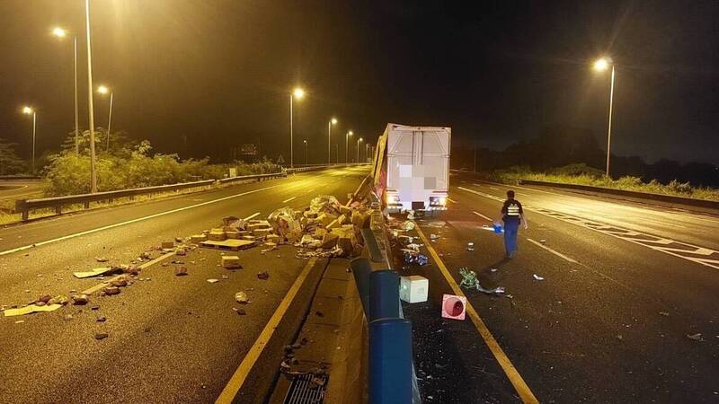 聯結車駕駛張男疑精神不濟，失控自撞內側護欄，車上物品掉落至對向車道及內側車道。（民眾提供）