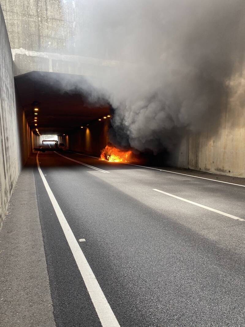 國道一號北上新竹市光復路出口涵洞今天下午近2點發生一起計程車火燒車事件，幸駕駛逃離無人受傷，消防人員獲報趕往現場滅火。（記者洪美秀翻攝）