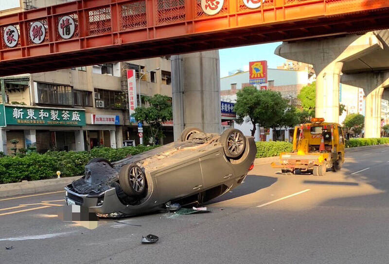 凌志轎車自撞分隔島後翻車，四輪朝天。（警方提供）