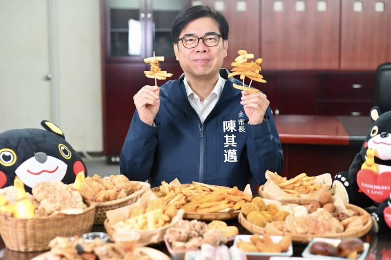 陳其邁po出滿桌鹹酥雞，雙手還拿著兩串炸物，邀大家本週六日來高雄。（記者王榮祥翻攝）