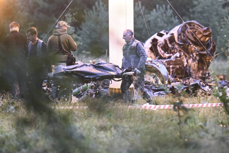 俄罗斯救援人员24日在坠机现场，从机残骸中抬出裹尸袋。（美联社）(photo:LTN)