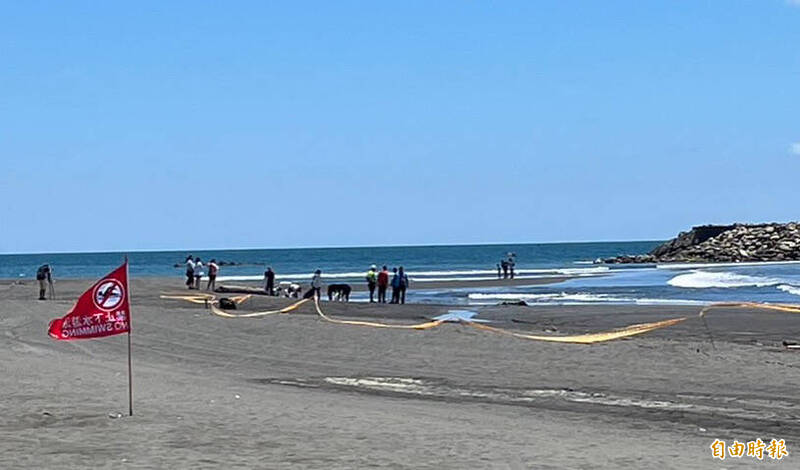 高雄旗津海水不明油污嚴重污染，遊客向旗津派出所求助清洗身體，旗津多處非開放的海岸沙灘及受污染區域，加強拉警戒線禁入。（記者黃良傑攝）