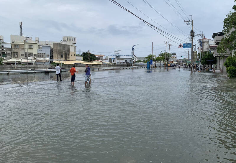 台南北門永隆溝也因大潮，海水一度溢淹上市道171線前北門衛生所、消防隊、圖書館的路面，阻斷交通。（北門公所提供）