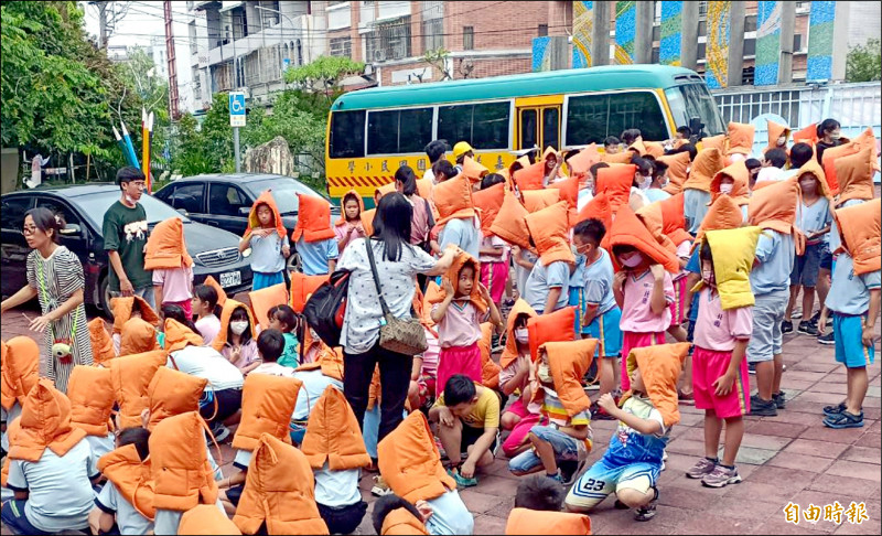 嘉義北園國小學生頭戴防震帽疏散。（記者林宜樟攝）