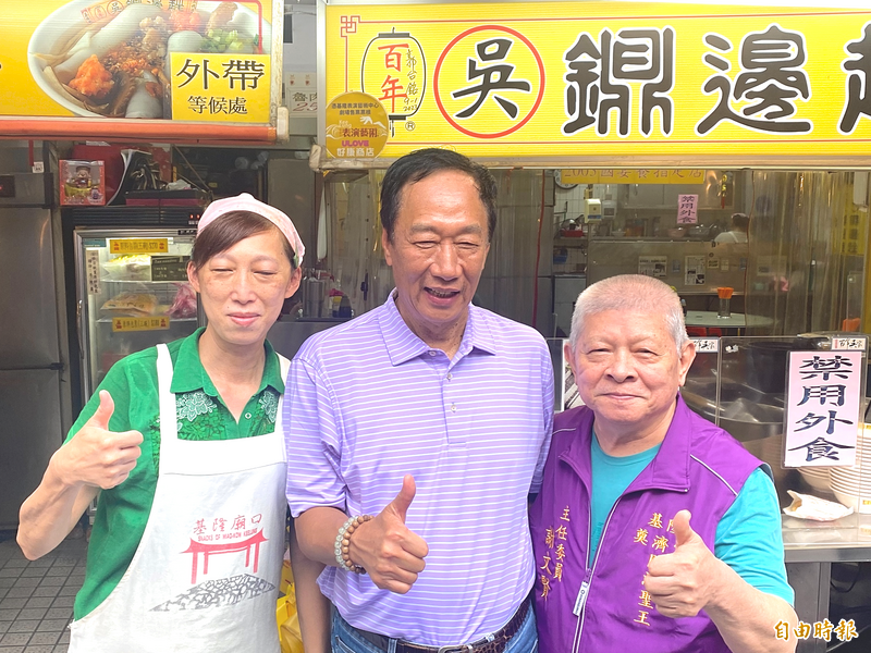 郭台銘今天到基隆廟口夜市奠濟宮參拜，逛夜市吃美食，對於合影來者不拒。（記者俞肇福攝）