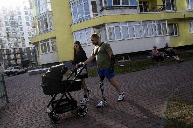 現在尤爾查克藉由義肢，已經可以推著嬰兒車帶女兒散步。（美聯社）