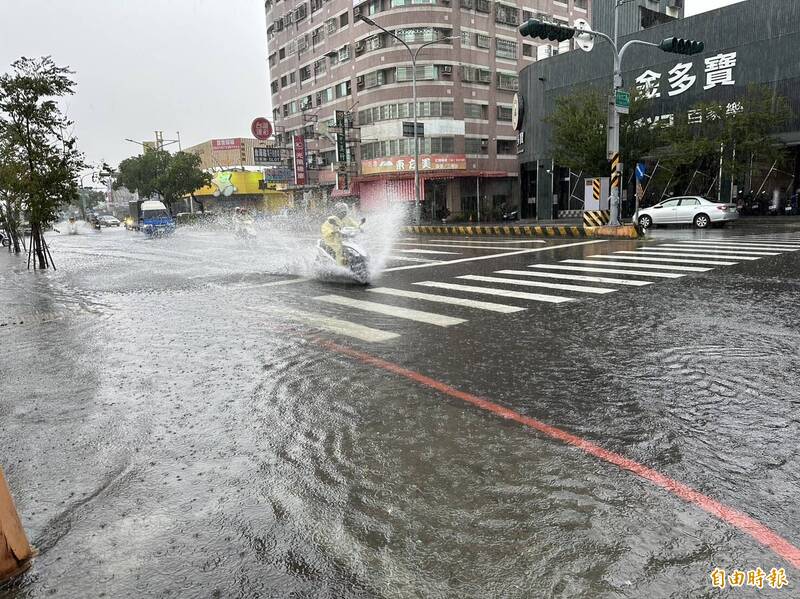 驟降的大雨讓台南市永康區永大路二段部分路段一度因宣洩不及而積水，汽機車經過濺起大量水花。（記者劉婉君攝）