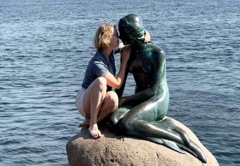 美國女遊客在大庭廣眾之下竟爬上丹麥哥本哈根「小美人魚」雕像，做出親熱動作。（圖擷取自「Ｘ」）