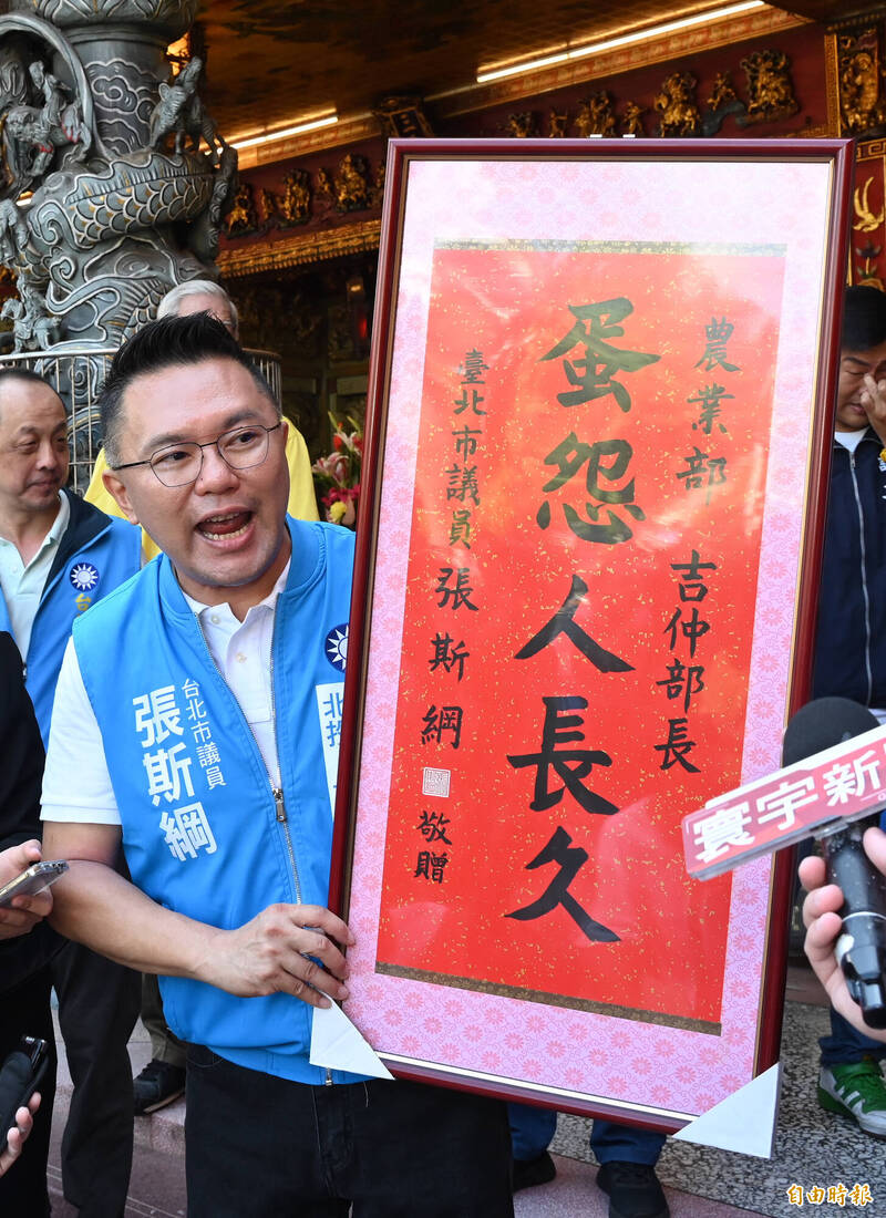 國民黨台北市議員張斯綱19日上午在黨主席朱立倫陪同下，前往天母三玉宮參拜，並預告下午將前往農業部，要致贈部長陳吉仲「蛋怨人長久」中堂。 （記者劉信德攝）