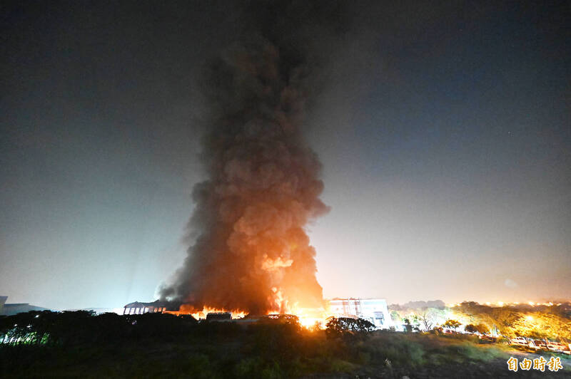 屏東明揚國際科技公司工廠爆炸起火，火勢從下午燒到隔天凌晨還在持續燃燒，現場濃煙直竄天際。（記者李惠洲攝）

