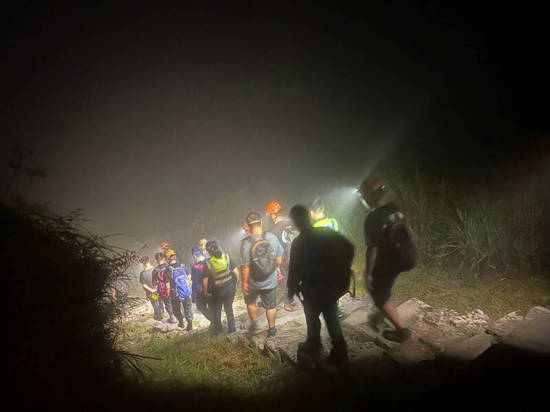 消防隊員登上茶壺山協助迷途的德國遊客安全下山。（記者吳昇儒翻攝）