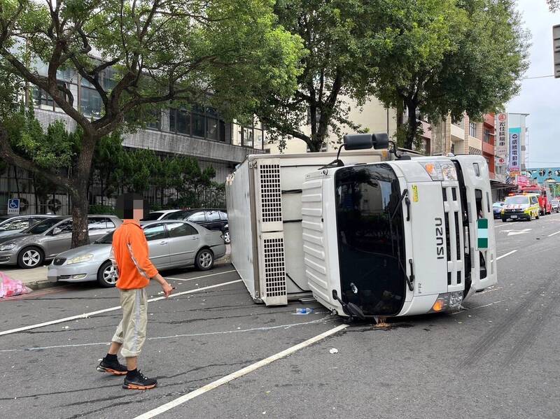 台1線桃園楊梅路段大貨車自撞分隔島翻覆橫躺路中央，駕駛、女乘客都受傷。（記者李容萍翻攝）