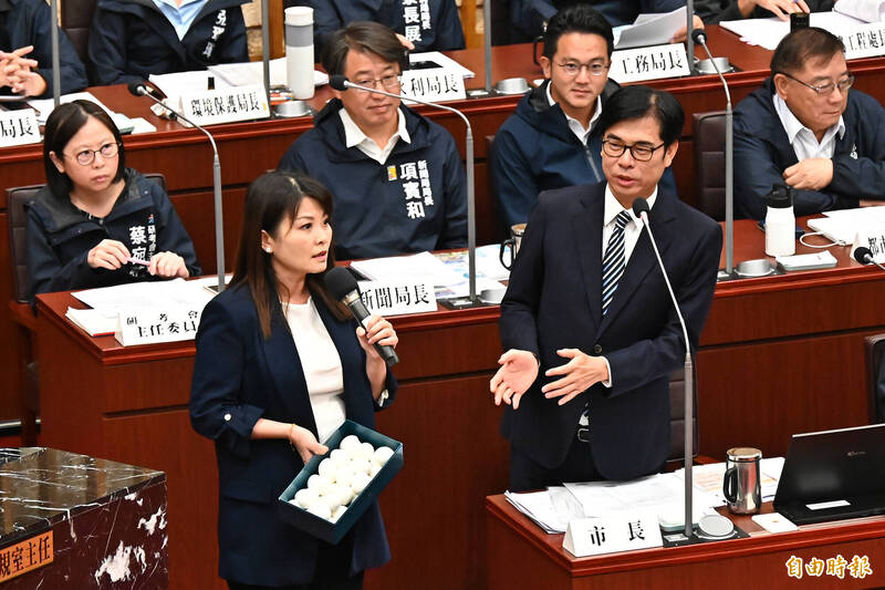 高雄市議員陳美雅（前排左）今天質詢時送雞蛋給市長陳其邁（前排右）與局處官員。（記者李惠洲攝）