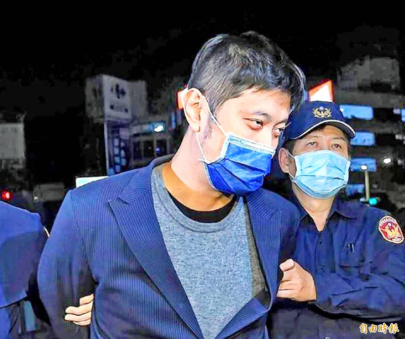 Raphael Lin, front, a former boyfriend of Democratic Progressive Party Legislator Kao Chia-yu, is escorted by police outside the New Taipei City District Court on Dec. 1, 2021.
Photo: Chen Chih-chu, Taipei Times