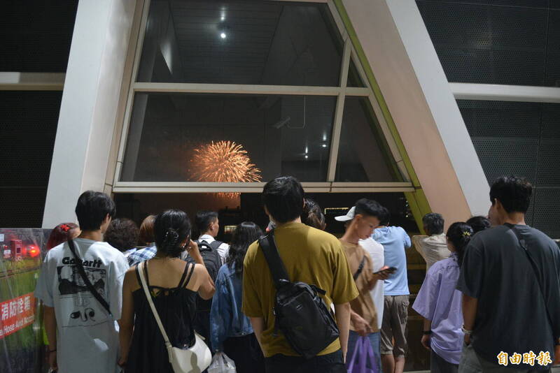 國慶焰火提早施放，搭乘捷運的民眾就近在文華高中站內欣賞。（記者陳建志攝）