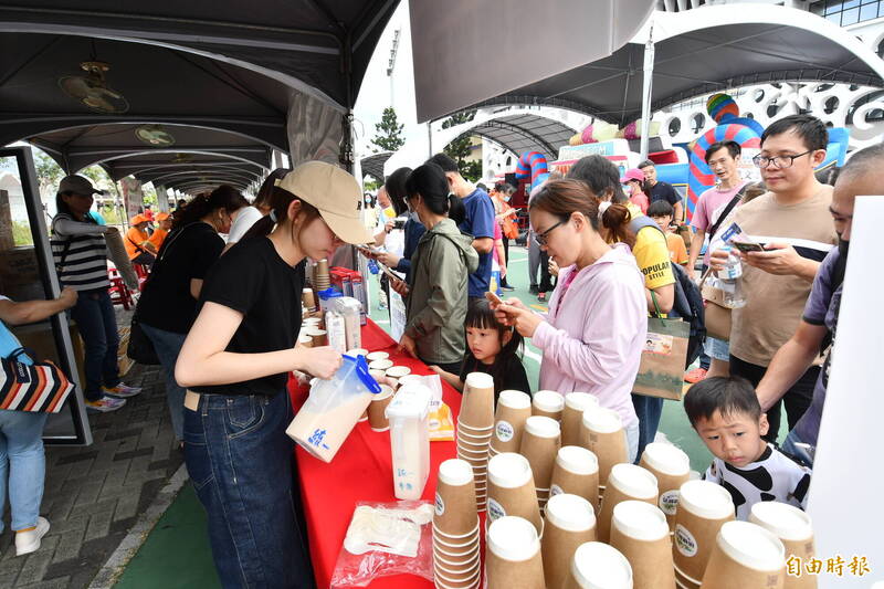 彰化乳牛節在縣立體育場紅磚區登場，民眾開心喝著國產牛乳。（記者劉曉欣攝）