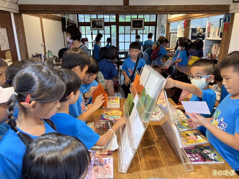 學生在永勝5號開心挑選明信片。（記者羅欣貞攝）