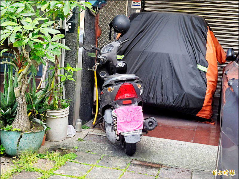 民眾被人檢舉怕了，將停在騎樓的汽車包起來、機車用毛巾蓋車牌。（記者葉永騫攝）