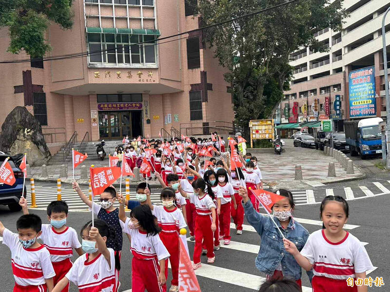 為提升學童行的安全，南投縣埔里國小全面推動學童舉旗、舉手過馬路，（記者佟振國攝）