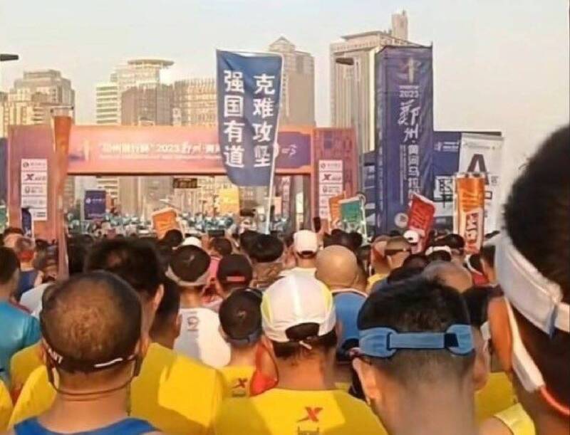 29日舉行的鄭州馬拉松比賽，在起跑點上有參賽者舉出藍色旗幟，上面分兩行豎立「克難攻堅，強國有道」白字，取首2字「克強」紀念前總理。（擷取自X平台）