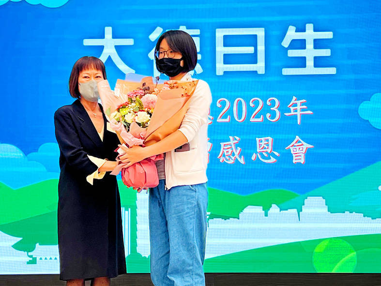 A representative of an organ donation recipient, left, presents a bouquet of flowers to a representative of an organ donor to show their gratitude at an event held by Taipei General Veterans Hospital yesterday.
Photo: CNA
