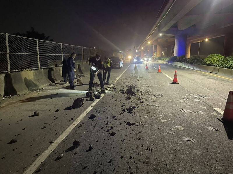 桃園平鎮台66平面道路一輛砂石車沿途掉落土石塊造成後方轎車車禍，員警和巡守隊員徒手清理路面。（記者李容萍翻攝）