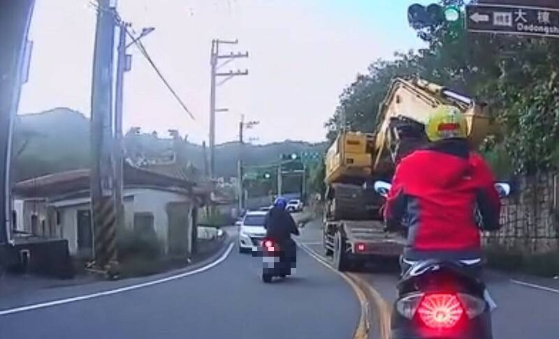 騎士在龜山區兔坑路彎道逆向超車，見對向有來車，遲疑一下才回到原車道。（擷取自龜山生活通臉書社團）