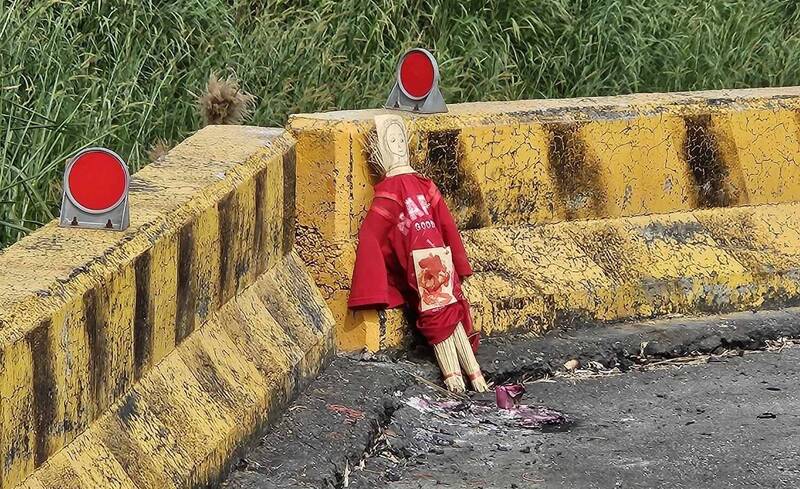 嘉義縣大林鎮三疊溪旁，一尊紅衣草人被放置在路邊。（記者林宜樟翻攝）
