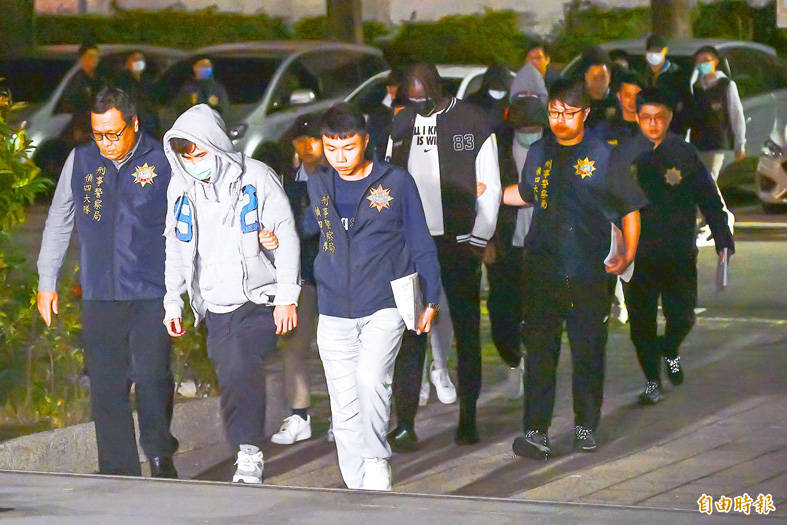 
Police escort Yulon Luxgen Dinos players to the Shilin District Prosecutors’ Office in Taipei on Friday.
Photo: Chen Chih-chu, Taipei Times