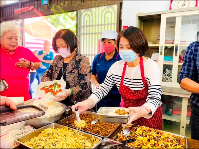 行政院副院長鄭文燦表示，因應食材漲價，明年將調升社區關懷據點基本維持費；圖為屏東縣長周春米幫據點長輩打菜。（資料照，屏東縣政府提供）