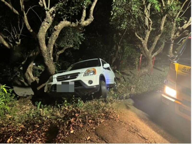 廖男透過導航抄捷徑，卻來到偏僻山區，迴轉時車輛滑落邊坡，幸好被一棵大樹卡住。（民眾提供）