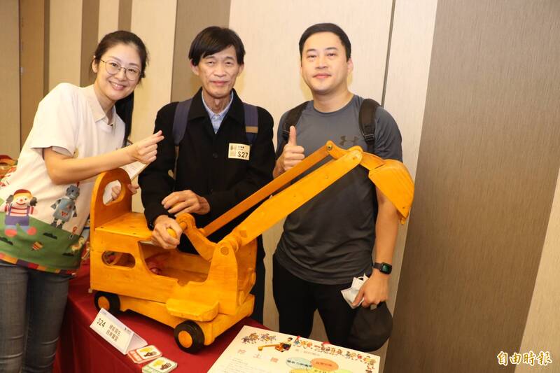 今年70歲的文浩華（中）  為愛孫創作挖土機兒童車， 獲得優選。（記者翁聿煌攝）