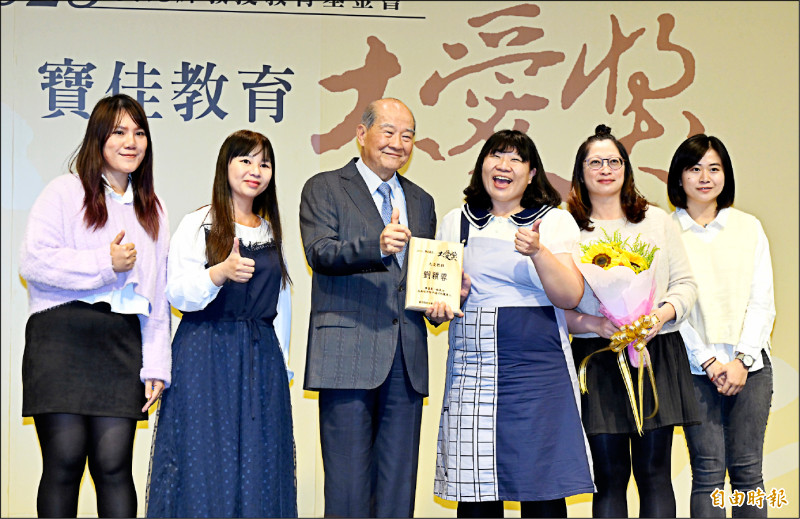 黃昆輝教授教育基金會董事長黃昆輝（左3）贈獎給大愛教師劉穎蓉（右3），並與親友團合影。
（記者廖振輝攝）