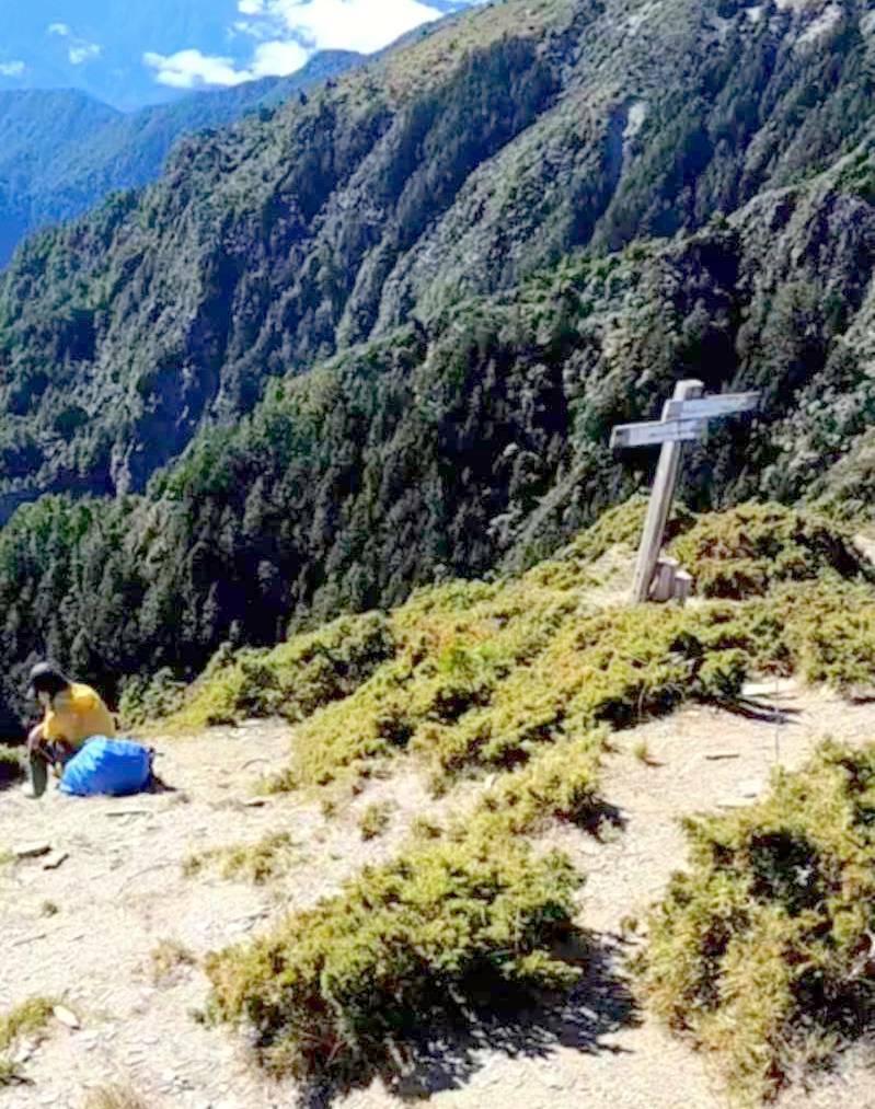 攀登馬博橫斷的女山友疑似高山症發作，在海拔高度約3454公尺的馬利亞文路山東峰一處平台等待救援。（圖由南投縣消防局提供）