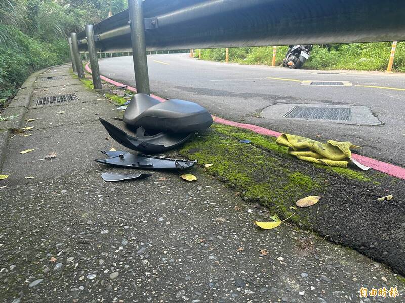 機車自摔後，坐墊、車殼散落一地，可見撞擊力道猛烈。（記者吳昇儒攝）