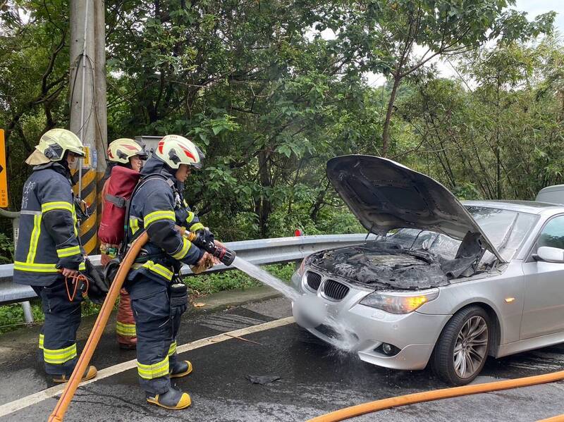 BMW轎車起火燃燒，消防人員獲報趕抵撲滅火勢。（記者陸運鋒翻攝）