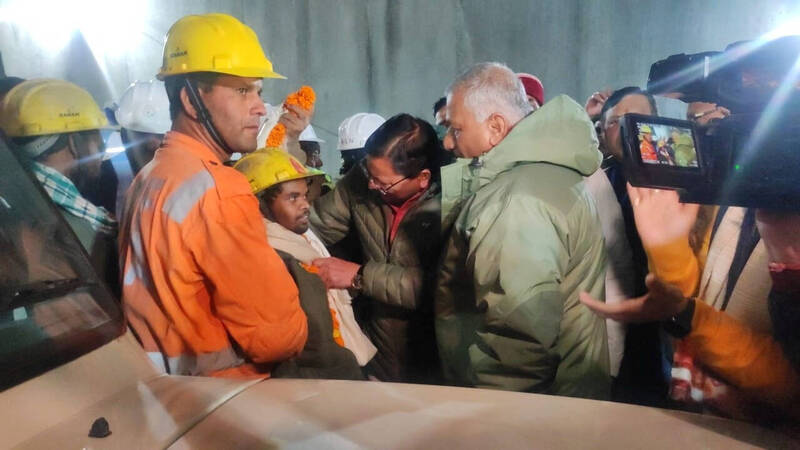 北阿坎德邦首席部長達米（中）向一名獲救的工人道賀。（路透）